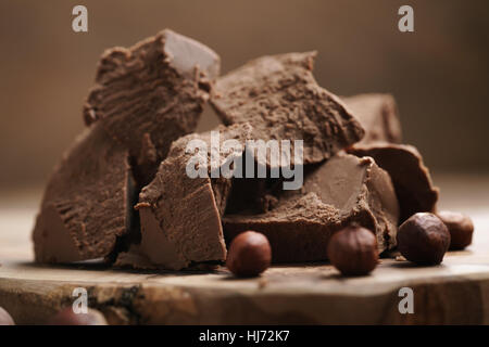 chunks of gianduja with hazelnuts on wood board Stock Photo