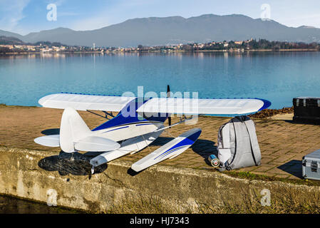 Small scale airplane. Radio controlled model seaplane. Float plane on the shore of a lake ready to fly Stock Photo