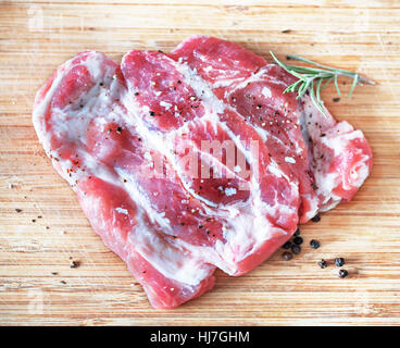 Raw pork meat steaks with spices on the white background. Stock Photo