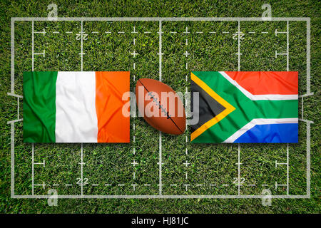 Ireland vs. South Africa flags on green rugby field Stock Photo