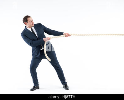 Strong and confident business leader. Side view of businessman in suit pulling a rope while standing against white background Stock Photo