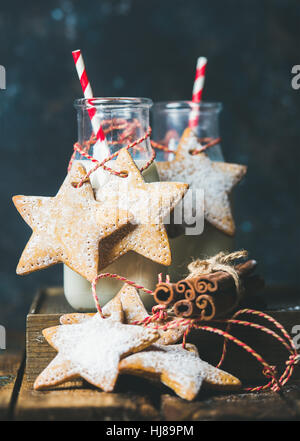 Bottles with milk and Christmas festive gingerbread star shaped cookies Stock Photo
