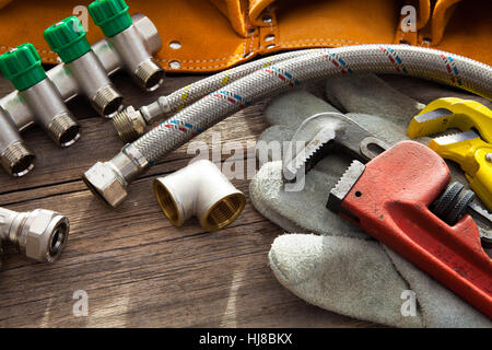 Set of plumbing and tools on the wooden table Stock Photo