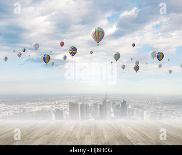 Colorful aerostats flying in clear sky above modern city Stock Photo ...