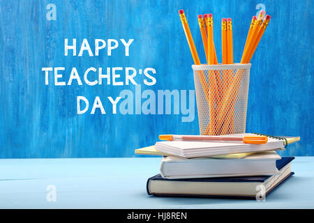 School supplies on blackboard background with inscription Teacher Day Stock Photo