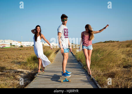 Three people walking along boardwalk, Tarifa, Cadiz, Andalucia, Spain Stock Photo