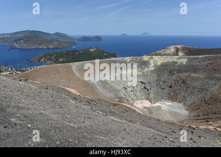 Walking around the Gran Cratere on Vulcano, one of the Aeolian Islands off Sicily, with Panarea and Stromboli in the distance Stock Photo