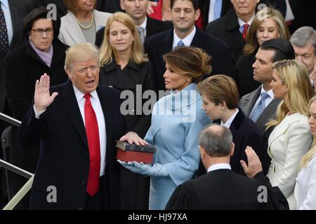 President Donald Trump takes the oath of office from Chief Justice John Roberts as his wife Melania, holds two Bibles, a personal family Bible and the Bible that President Lincoln used at his first inauguration and surrounded by his five children January 20, 2017 in Washington, DC. Trump became the 45th President of the United States. Stock Photo
