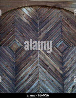 Close up of old arched gate with diamond pattern. The wood is weathered gray and brown. Located in Taltsy Village, Siberia Stock Photo