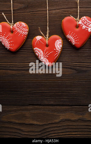 Line of red gingerbreads hearts on ribbon. Stock Photo