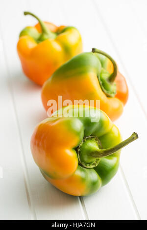 Multicolored bell pepper on white table. Stock Photo