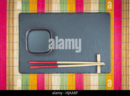 Chopsticks  and soy sauce on slate top view Stock Photo
