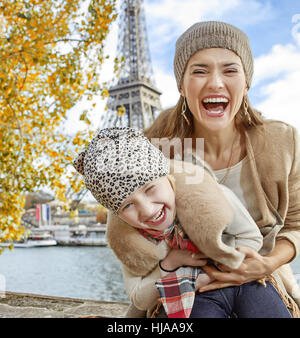 Autumn getaways in Paris with family. happy mother and child tourists on embankment in Paris, France having fun time Stock Photo