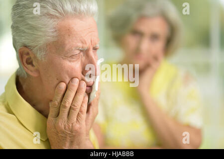 mature man having toothache, his wife Stock Photo