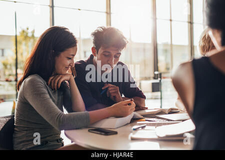 Two young students reading a book in library. university students studying together in class. Stock Photo
