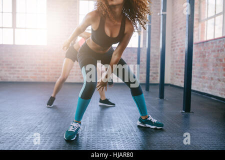 Cropped shot of young females doing running workout in the gym.  Focus on legs of women. Stock Photo