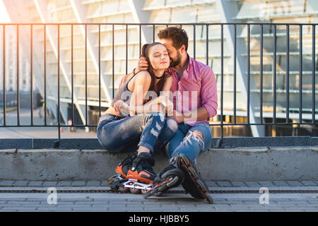 Couple of inline skaters sitting. Stock Photo