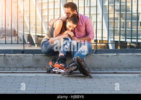 Couple of rollerbladers sitting. Stock Photo