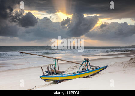 Beached fishing boat and dramatic sky at sunset, Taiba, Ceara, Brazil