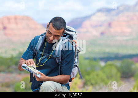 Young male hiker looking at map, Sedona, Arizona, USA Stock Photo