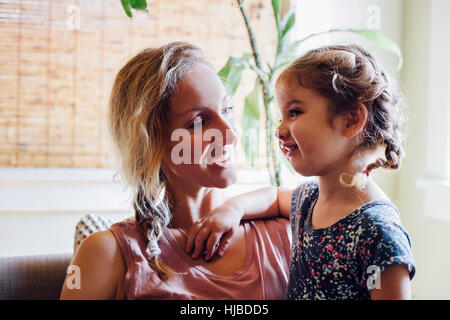 Woman and toddler daughter relaxing on sofa Stock Photo