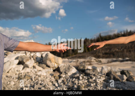 Couple reaching hands out to each other, Ottawa, Ontario Stock Photo