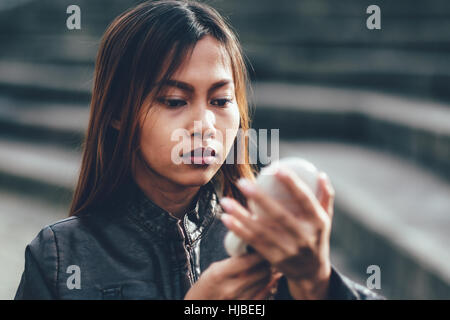 Girl on the street looking at the makeup mirror Stock Photo