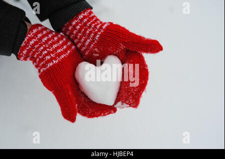 woman in red mittens holding a snowy heart Stock Photo
