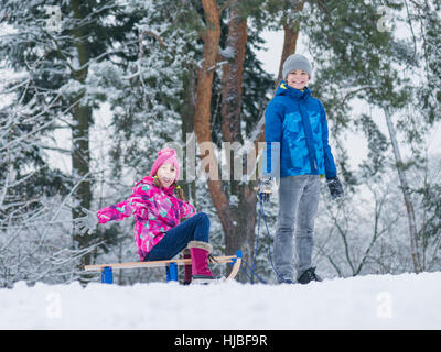 Child play in snow with sled Stock Photo
