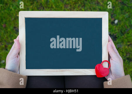 Table for Valentine's Day. Heart shaped red padlock on blackboard Stock Photo