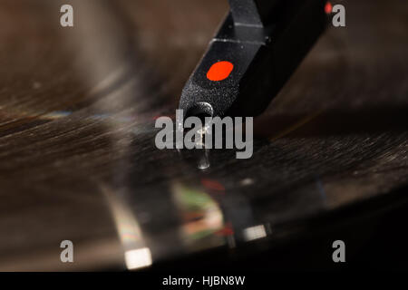 Spinning vinyl record on turntable with motion blur, closeup on stylus needle and head shell Stock Photo