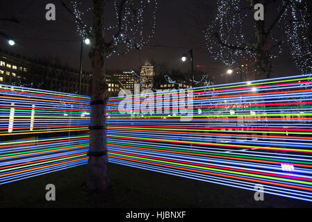 London, UK. 23rd Jan, 2017. Horizontal Interference at Winter Lights Canary Wharf, made by Joachim Slugocki and Katarzyna Malejka, two artists from Poland. It is composed by a modular site-specific installation links the tops of trees with streams of light. Credit: Alberto Pezzali/Pacific Press/Ģ����ý Live News Stock Photo