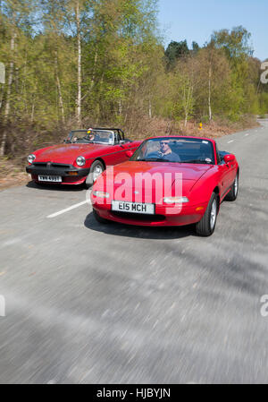 Mazda MX5 and MGB roadster open top sports cars driving together on a summers day Stock Photo