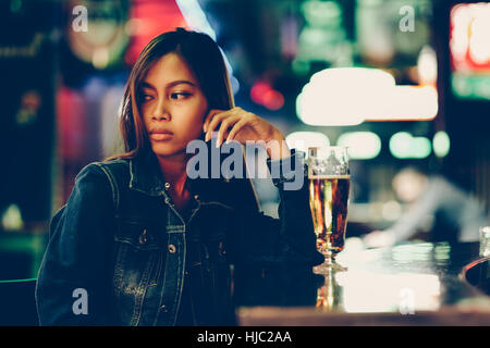 Night life, adult girl waiting in the Bar drinking bear Stock Photo