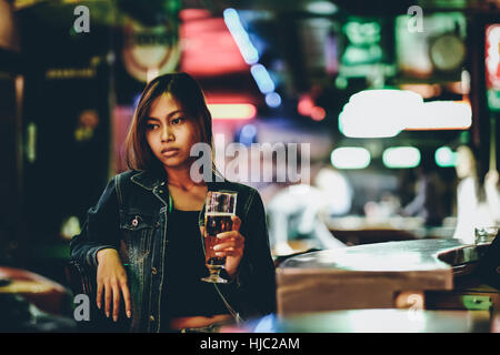 Night life, adult girl waiting in the Bar drinking bear Stock Photo