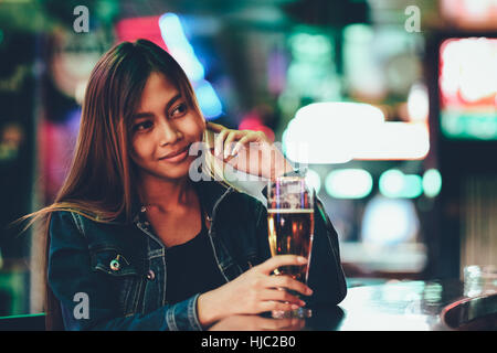 Night life, adult girl waiting in the Bar drinking bear Stock Photo