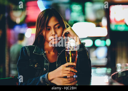 Night life, adult girl waiting in the Bar drinking bear Stock Photo