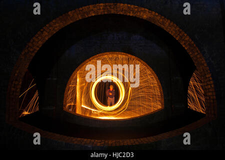 Spinning ignited wire wool to create an atmospheric image in Finsbury Park Underground Reservoir, North London. Stock Photo