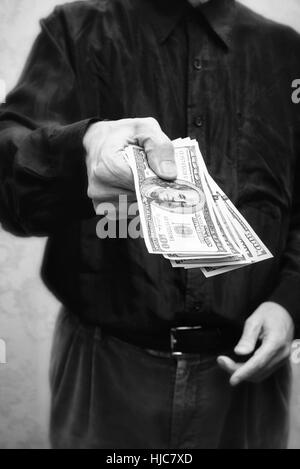 Corrupted businessman, or politician, offering a Dollar banknotes bribe Stock Photo