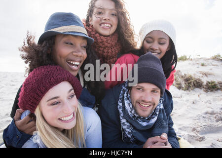 Portrait of young adult friends lying on top of each other on beach, Western Cape, South Africa Stock Photo