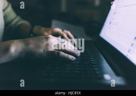 Hand of young woman typing on laptop Stock Photo