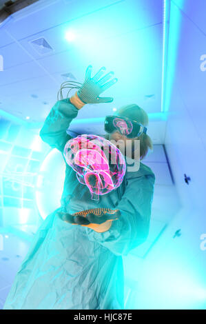 Boy in virtual reality headset interacting with digital floating human brain Stock Photo