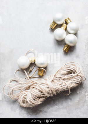 Overhead view of white Christmas baubles with string Stock Photo