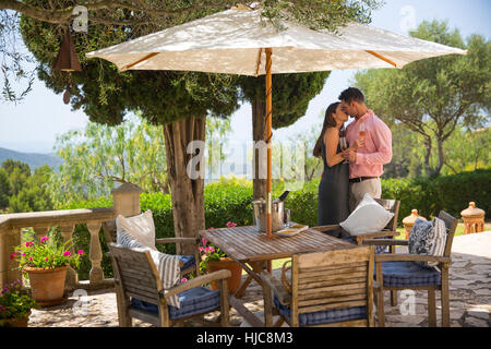 Romantic couple kissing on patio at boutique hotel, Majorca, Spain Stock Photo
