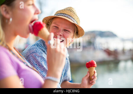 Young couple laughing and eating ice cream cones on waterfront, Majorca, Spain Stock Photo