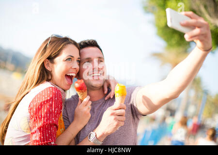 Couple taking selfie eating ice cream cones, Majorca, Spain Stock Photo