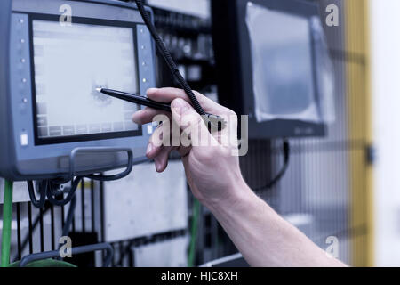Engineer in engineering plant, using stylus on screen, close-up Stock Photo