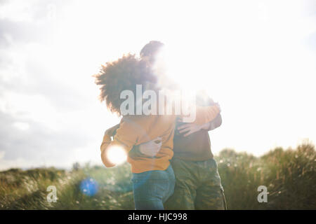 Couple dancing on grassy sand dune Stock Photo