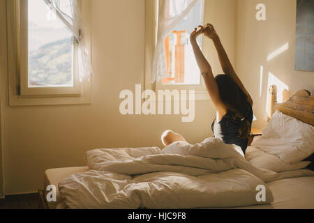 Woman stretching in bed Stock Photo