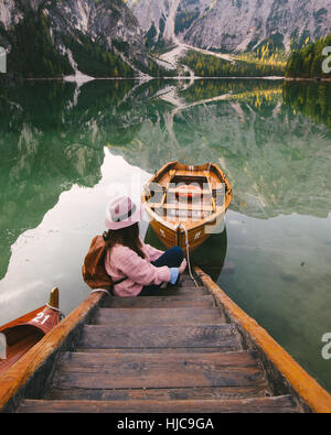Woman relaxing on pier, Lago di Braies, Dolomite Alps, Val di Braies, South Tyrol, Italy Stock Photo